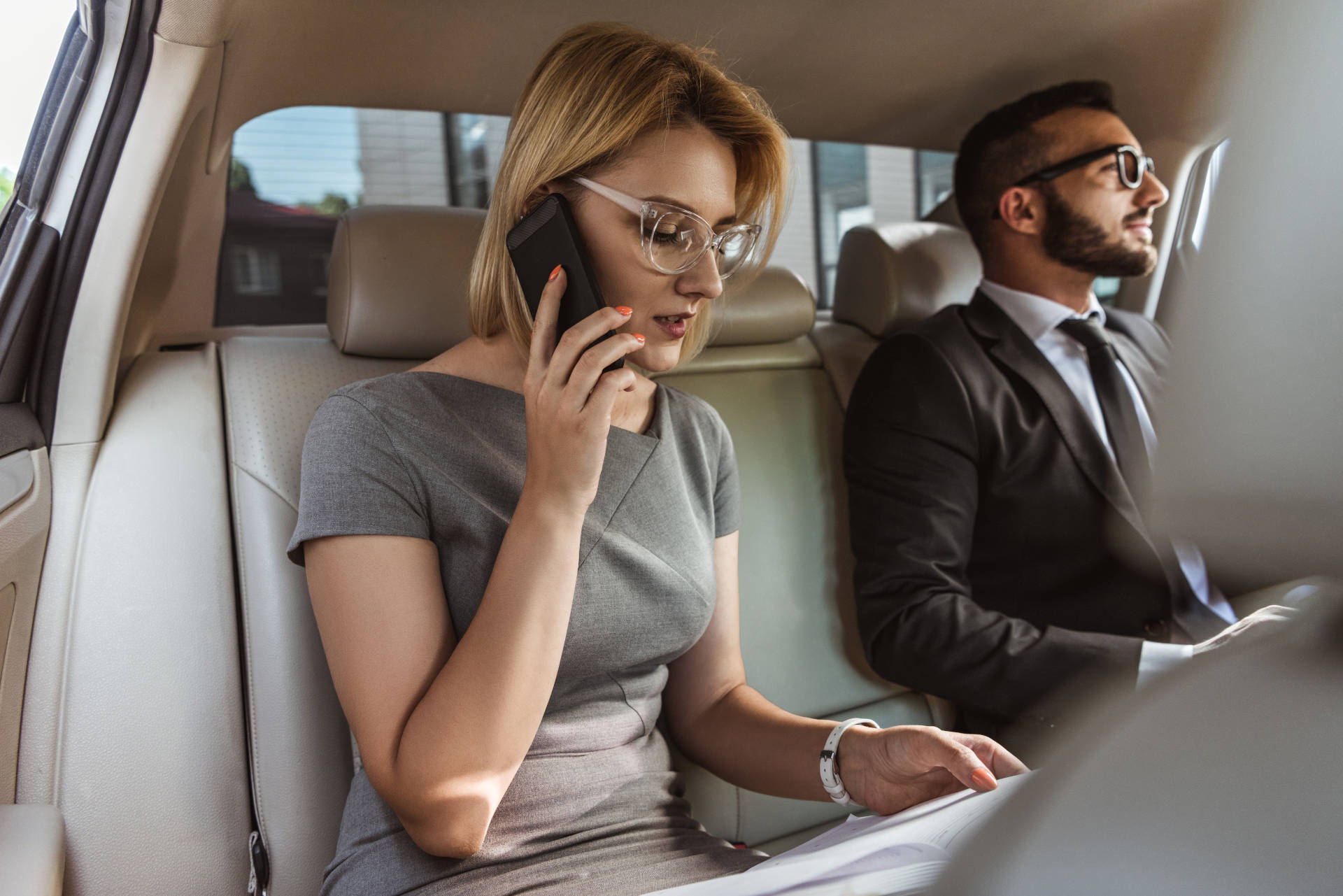 Two business travelers in a luxury car